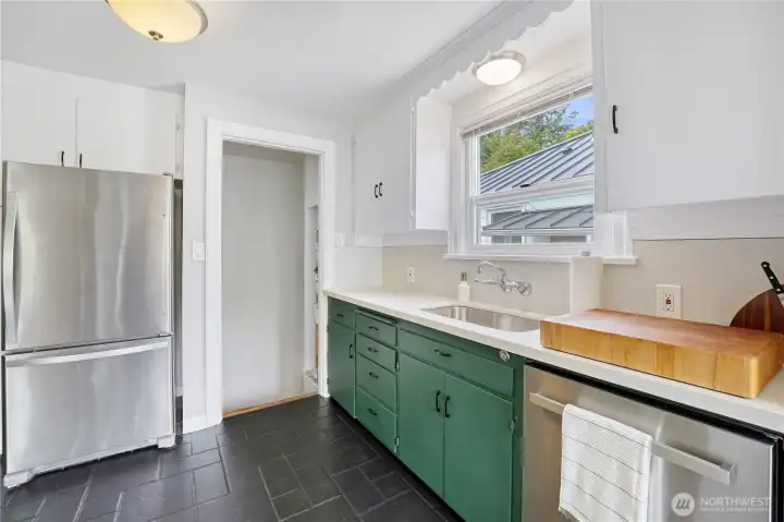 A modern kitchen with stainless steel appliances, an eating nook, and quartz