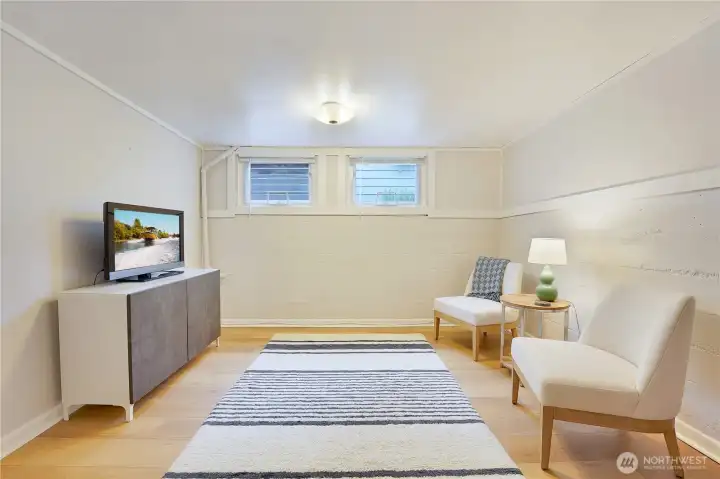 Enormous lower level bedroom with sitting area has high ceilings.