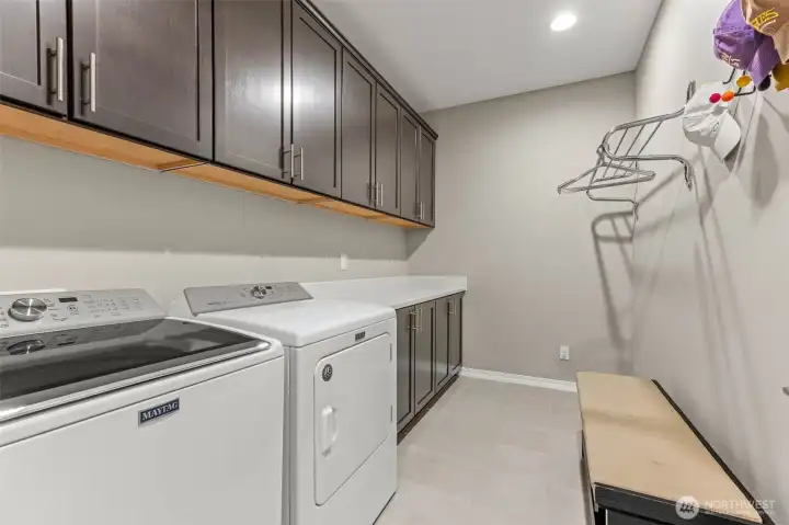 Full laundry room with spacious counter and cabinets