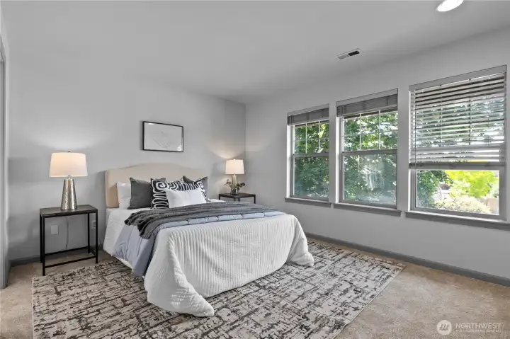 Spacious primary suite with generous natural light and room for a king-sized bed plus additional furnishings.