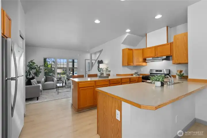 A large peninsula provides additional workspace, storage, and bar seating.