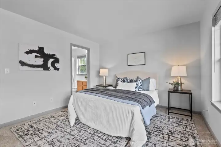 A comfortable retreat featuring an open layout, large windows, and direct access to the attached bath.