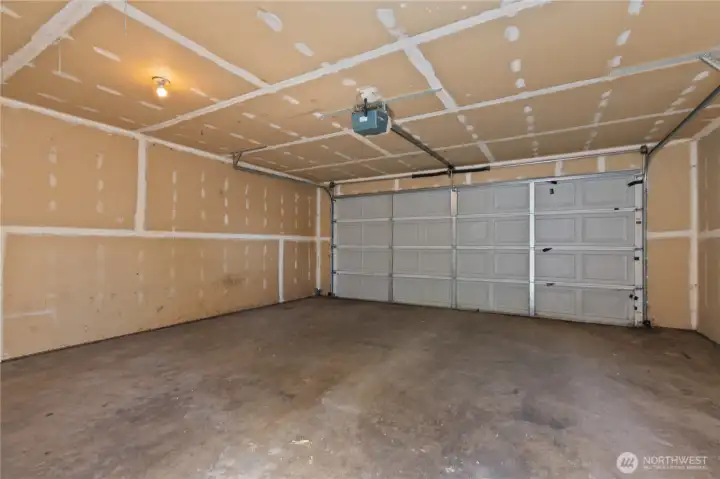 Spacious attached two-car garage offers additional room for parking, storage, or workshop space.