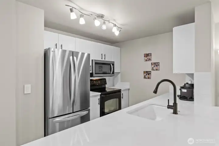 Remodeled kitchen featuring quartz countertops, stainless steel appliances, and updated cabinetry — a rare fully renovated find in Everett's gated Bluegrass community.