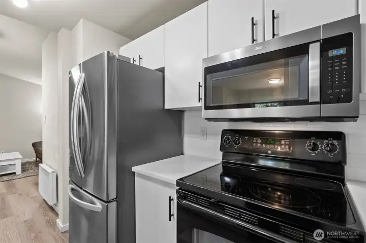Modern stainless steel range and microwave in the newly renovated kitchen of this turnkey Bluegrass Condominiums home in Everett, WA.