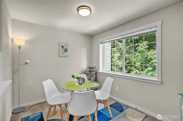Dining nook framed by large windows with peaceful, tree-lined views — a standout feature of this renovated Bluegrass Condominiums unit.