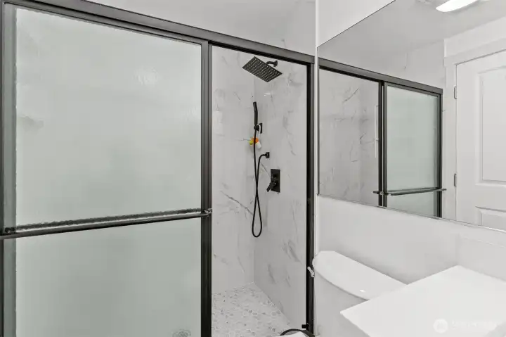 Sleek glass-enclosed shower — one more upgrade that sets this Bluegrass Condominiums unit apart from other listings in the complex.