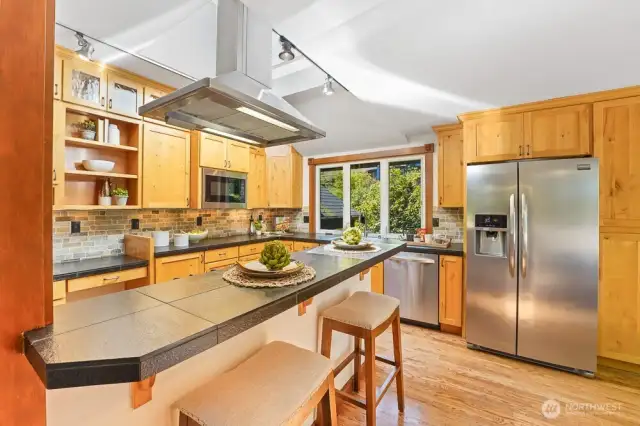 Updated Chef's kitchen includes SS steel appliances, gas stove, granite countertops, and solid wood cabinets.