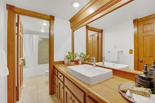 Lower level full bath includes heated ceramic tile floors, tiled shower/tub, and large custom vanity.