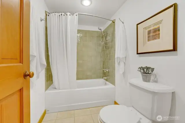 Lower level full bath includes heated ceramic tile floors, tiled shower/tub, and large custom vanity.