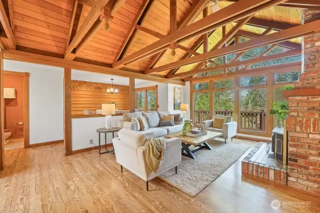 Soaring Vaulted cedar ceilings and a cozy woof-burning fireplace crate a warm, inviting living space