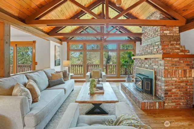 Soaring Vaulted cedar ceilings and a cozy wood-burning fireplace crate a warm, inviting living space