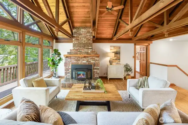 Soaring Vaulted cedar ceilings and a cozy wood-burning fireplace crate a warm, inviting living space