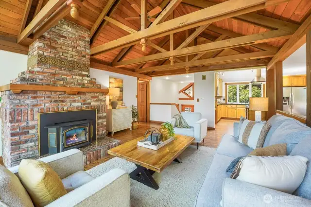 Soaring Vaulted cedar ceilings and a cozy wood-burning fireplace crate a warm, inviting living space