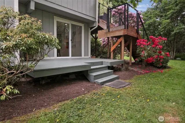 Versatile side yard deck offers seamless access to the lower-level family room or a tranquil garden retreat. Enjoy the lush greenbelt, alive with the sounds of nature.