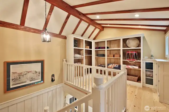 The second level has tongue and groove white pine floors with period Rosehead nails. This is the landing at the top of the stairs with custom built shelving and cabinets for storage.