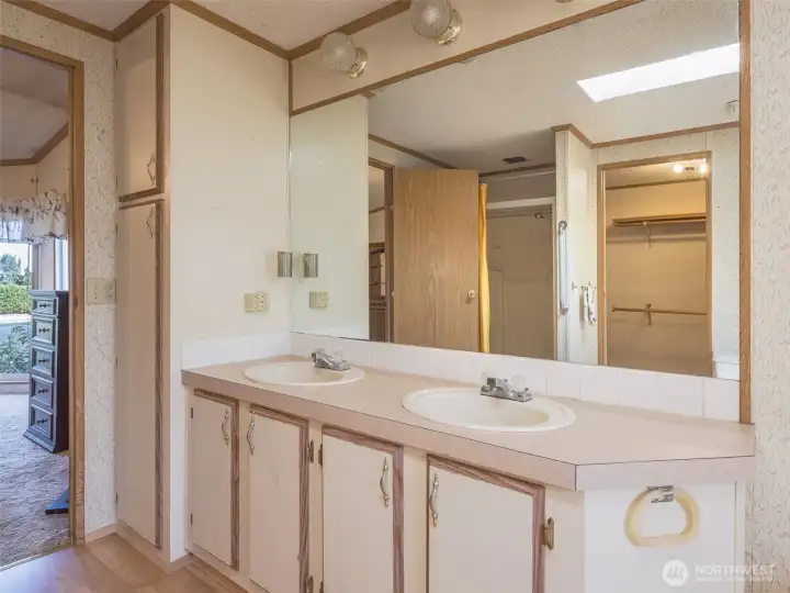 The primary bathroom features double sinks and ample storage with a built-in linen cabinet.