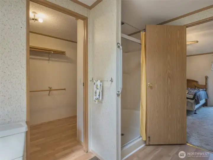 The walk-in closet in the primary bedroom offers dual access, with doors connecting both the bedroom and the en-suite bathroom for added convenience.