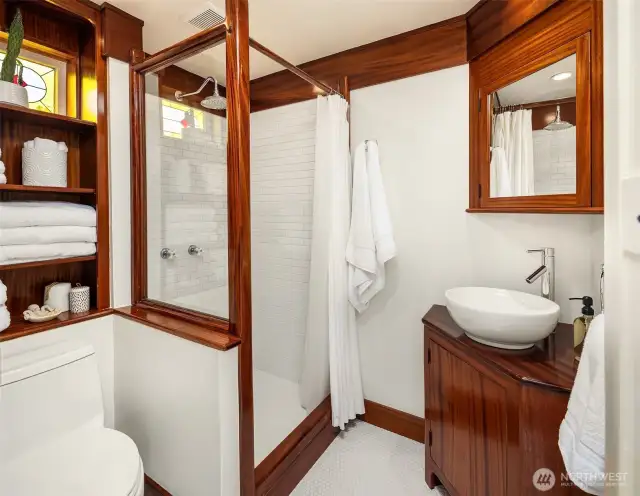 Spacious bathroom with luxurious shower and custom woodwork throughout.