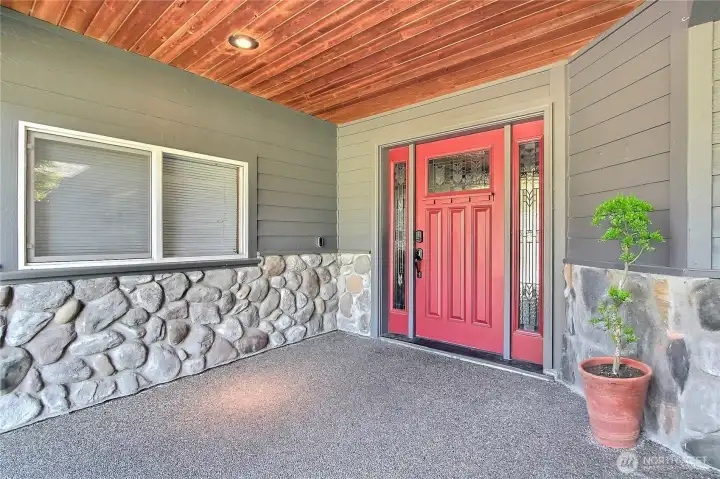 Shot of your front entry, grand in scale. I love all the stone, the huge covered area with wood on the ceiling - very PNW. Custom door with leaded glass as well. Nest doorbell stays. Welcome home!