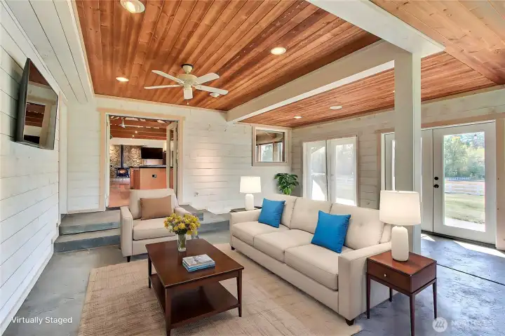 View of the 4-season covered patio, AKA White Room. The stamped concrete floor is amazing, as are all the French Doors and screens leading to your extended patio. Love the wood ceiling and painted shiplap, just a very peaceful room we have found and we use it all year. It has a convenient ceiling fan and it's own cadet heater for chilly nights. Door to your left in the corner leads to your 3/4 bath. ***Virtually Staged***