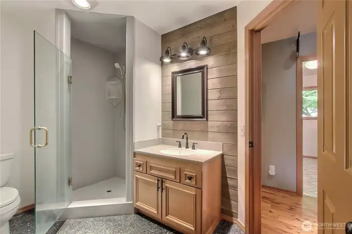 Main floor 3/4 bath, really nice tile flooring, quality vanity, door to your right leads to hallway with laundry room, beds and additional bathroom. Door out of view to your left leads to White Room.