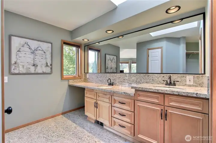 Primary ensuite bath view one, love the custom cabinetry, granite tiered double vanity with huge mirror. Quality tile flooring and skylights are really nice as well.