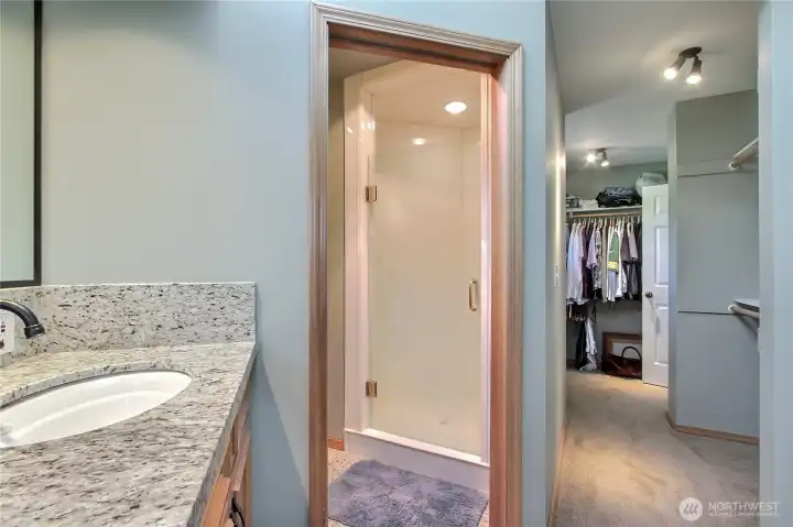 Primary ensuite bath view two showing your shower and water closet with toilet and pocket door, one of your walk-in closets to your right.