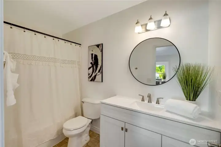 Updated full bath with new vanity, lights & mirror.