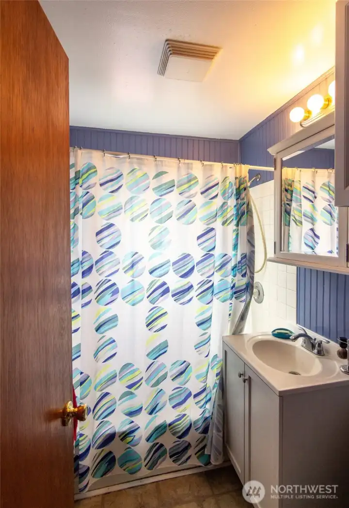 The bathroom has a shower/tub combo.