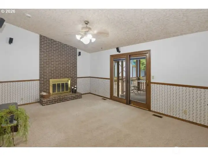 Wood burning fireplace. Triple pane door with built in shades leads to catio.