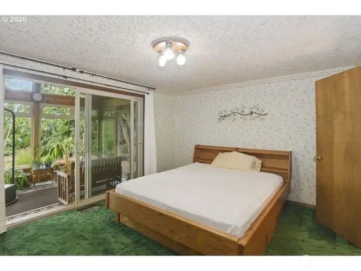 Primary bedroom with attached bathroom with walk-in tub and shower. Sliding door to sunroom.