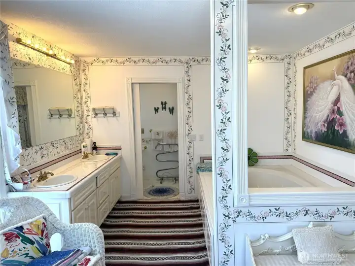 Luxurious s bath with jetted tub, two sinks and a water closet with a shower.