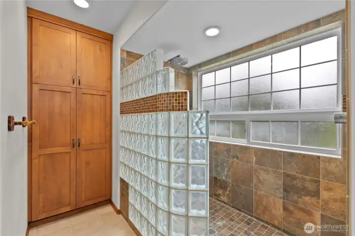 Oversized primary bathroom with walk-in shower and extra linen storage
