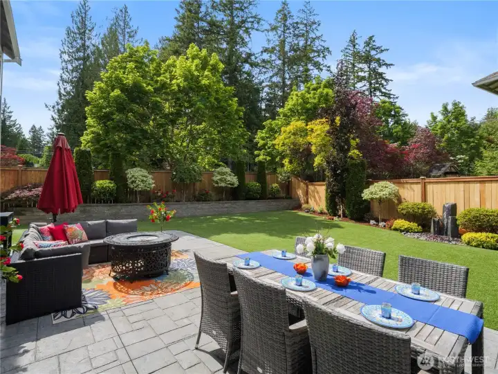Enjoy resort-style outdoor living with expansive patio spaces, manicured grounds, and a private setting surrounded by mature trees.