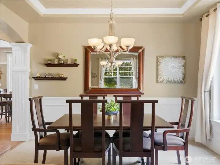 Entertain in style in this elegant dining room, where custom millwork, soaring tray ceilings, and abundant natural light create an exceptional setting.