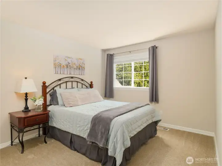 Secondary bedroom with large window and peaceful views, ideal for guests.