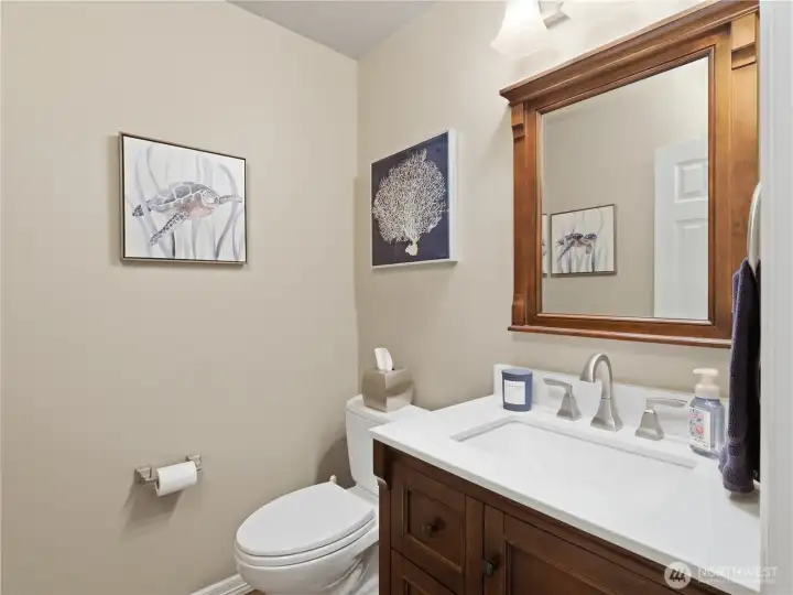 Updated main floor powder room with quartz counters, custom cabinetry, and contemporary fixtures.