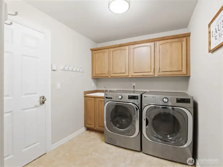A spacious laundry room with built-in storage and utility sink helps keep daily routines organized and efficient.