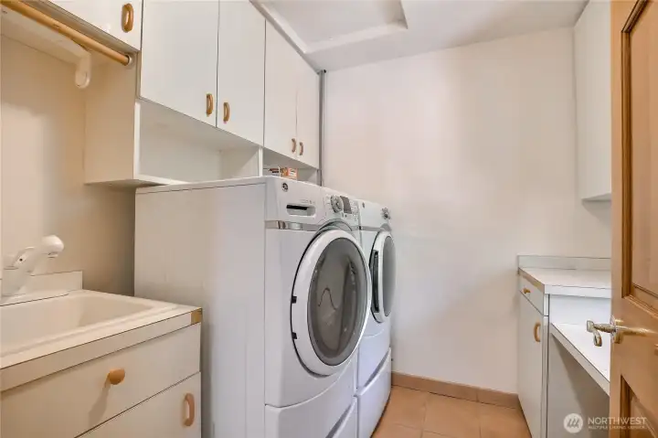 Laundry room has cabinets, sink and folding counter Laundry room has cabinets, sink and folding counter
