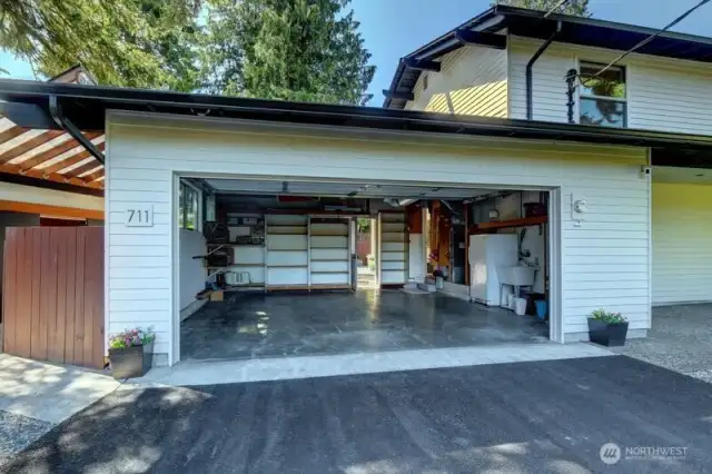 Garage  240V outlet for EV charging  Wash basin with hot water hookup  Freezer space  2 Car Garage with Overhead rafter pulley storage (kayaks, etc.), Bicycle storage hooks (3 total), & Quiet garage door & opener (2021).