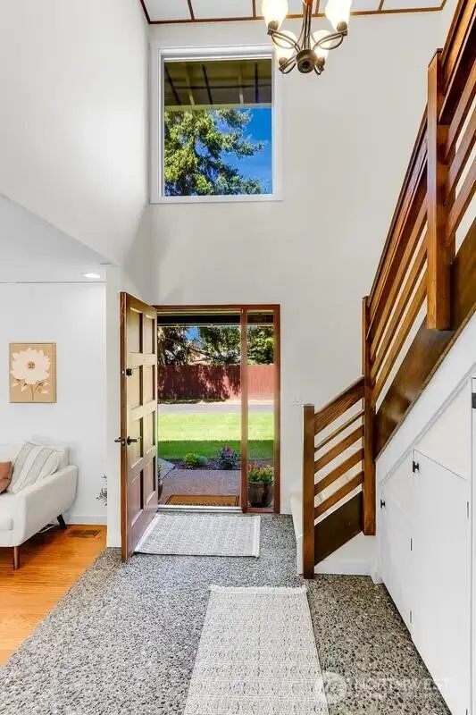 Bright entry way window brings in tons of sunlight!  Sturdy custom wood railing for stairs is built to last a lifetime!