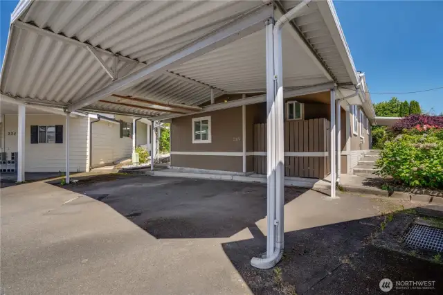 The two-car covered carport provides protection from the elements. The window to the left is for the storage area off of the back of the home. There is also a storage area on the right side of the home behind the fenced in area.