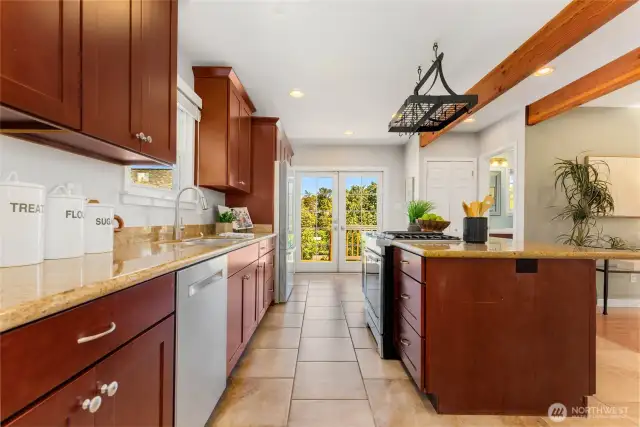 Enormous kitchen with granite tile counters, custom cherry cabinets, and matching stainless appliances