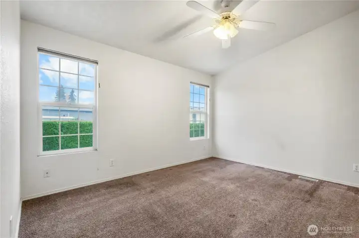 The primary bedroom offers 2 windows (with blinds) and a ceiling fan.