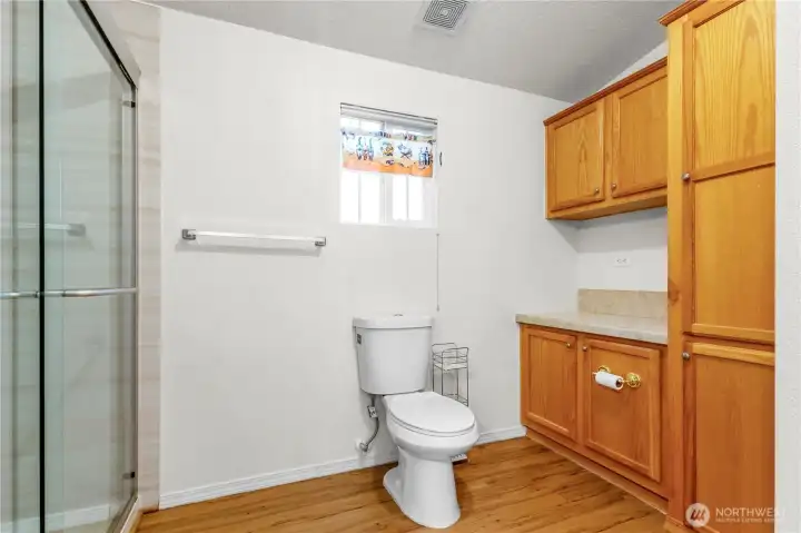 The primary bathroom offers a large step-in shower, ample counter space, and plenty of storage to keep everything organized.