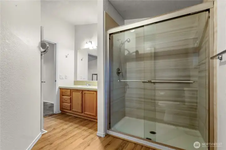 Large low step shower and vanity in primary bathroom.