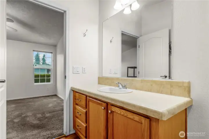 Another view of primary bathroom vanity back toward the bedroom.