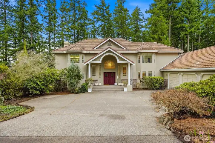 Inviting front entry with long private driveway and mature landscaping, showcasing this luxury Maple Valley lake view home in the highly desirable Tahoma School District.