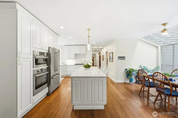 Open dining space connected to the kitchen with warm wood flooring and abundant natural light—perfect for gatherings in this Lake Wilderness view home.